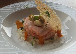 Salmon medallion with truffle on a artichokes velout&#233; with foamed parmesan milk