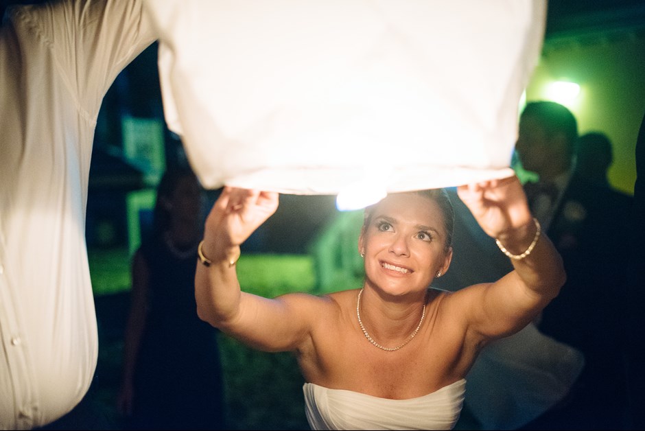 Bride lighting lantern on the beach at Fairmont